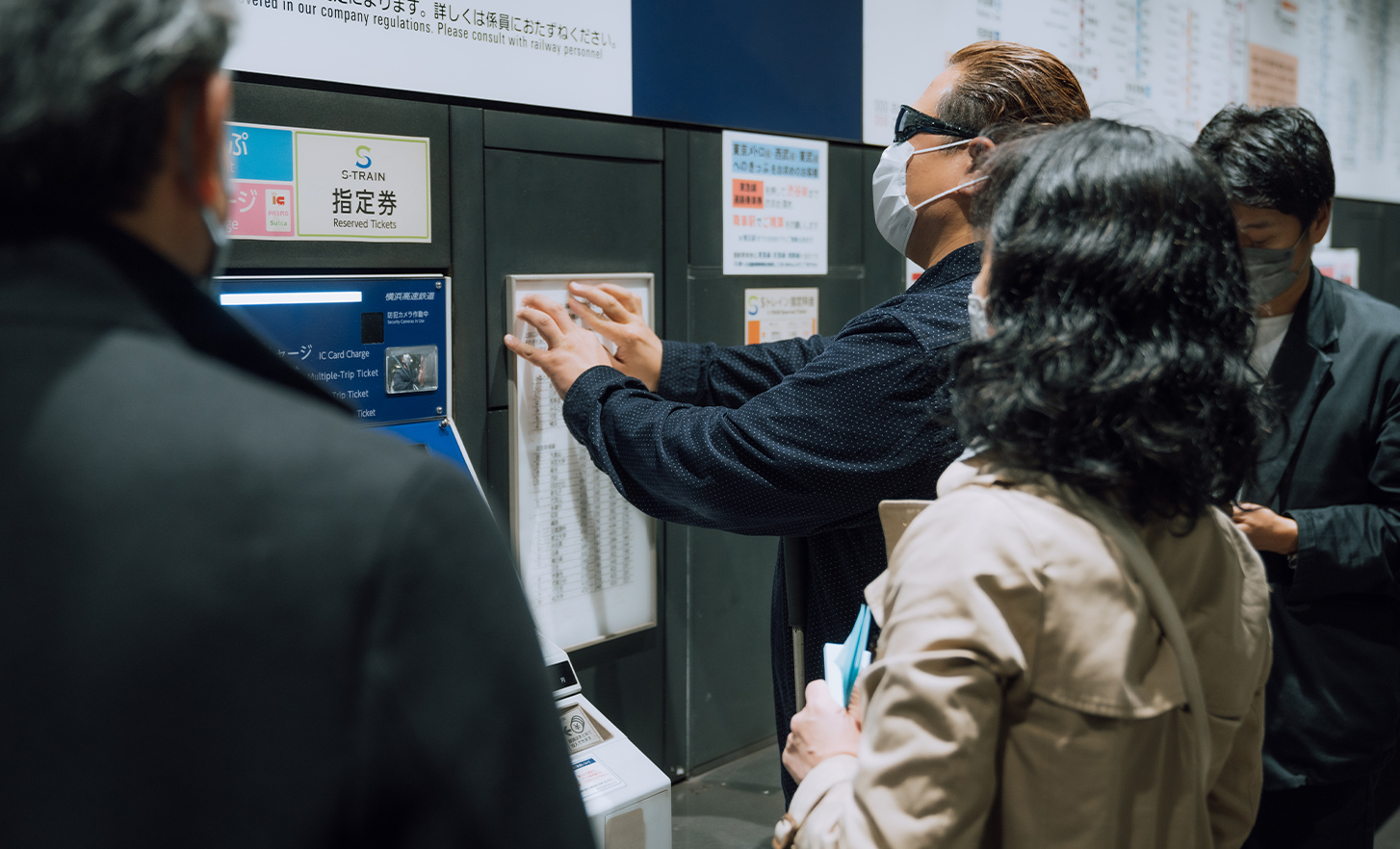 The lead user is buying a ticket at a ticket vending machine