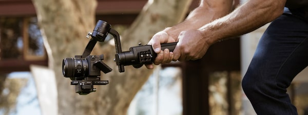 Photo of man shooting video with the camera on a gimbal