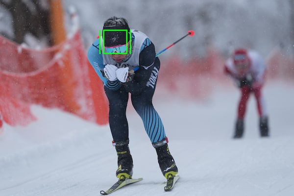 Image of a skier in motion, with a tracking indicator mark superimposed over the skier's head