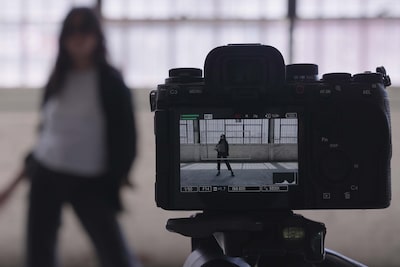 Example image of the camera mounted on a tripod, filming a woman