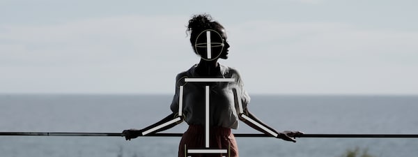 Photo of a woman silhouetted against the ocean