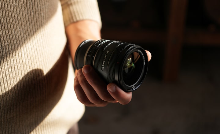 View of lens barrel held in user's hand, showing the compact lens size