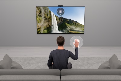 Person on a sofa controlling TV with hand gestures