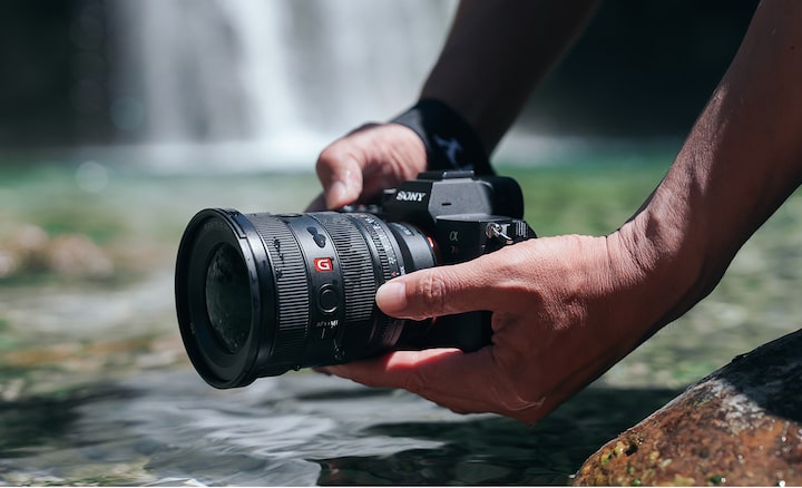 Close-up image of a person shooting by the water.