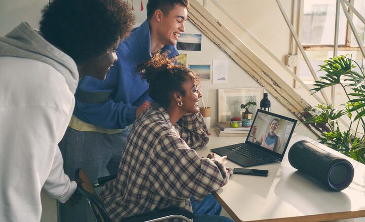 Image of people surrounding a laptop and the SRS-XG300 X-Series Portable Wireless Speaker